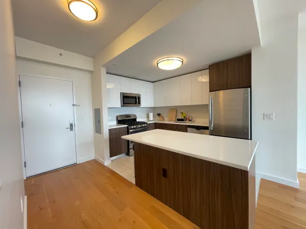 a kitchen with a refrigerator a stove top oven a sink dishwasher and wooden cabinets