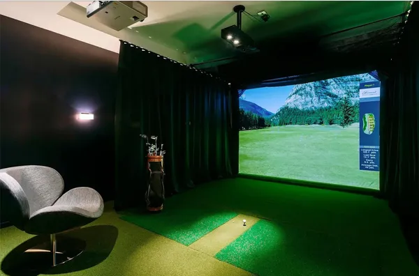 a room with furniture projector and screen