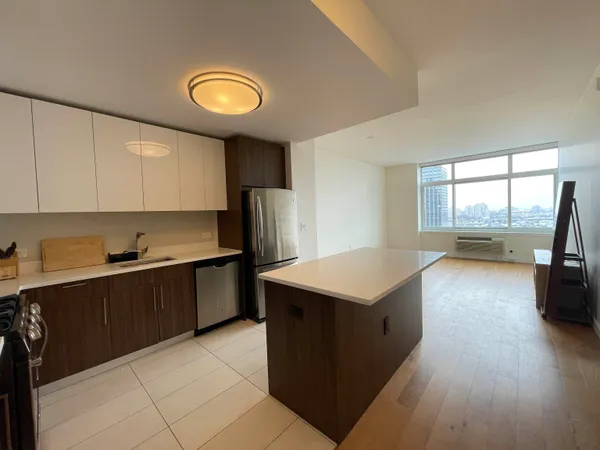 a kitchen with a refrigerator a stove top oven a sink dishwasher and wooden cabinets with wooden floor