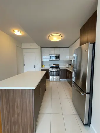 a kitchen with stainless steel appliances a refrigerator a stove a sink and a refrigerator