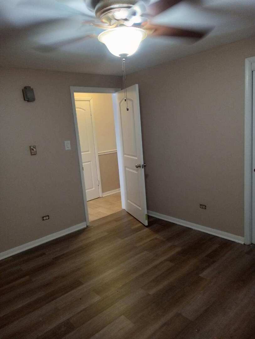 2915 West 79th Street, Unit G Chicago, IL 60652 - Photo 5 of 13 an empty room with wooden floor and windows