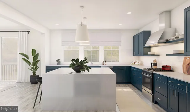 a kitchen with stainless steel appliances a sink a counter top space cabinets and a potted plant