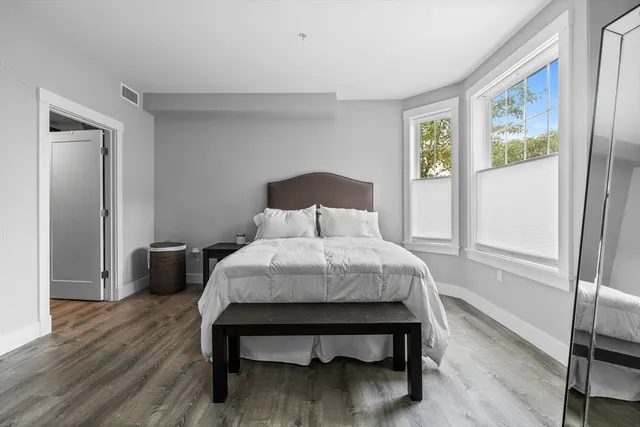 a bedroom with a bed and wooden floor