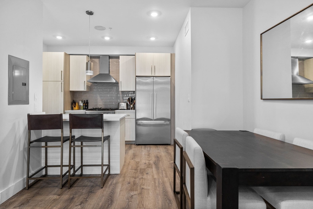 176 Humboldt Avenue, Unit 2 Boston, MA 02121 - Photo 2 of 23 a kitchen with a table chairs refrigerator and cabinets