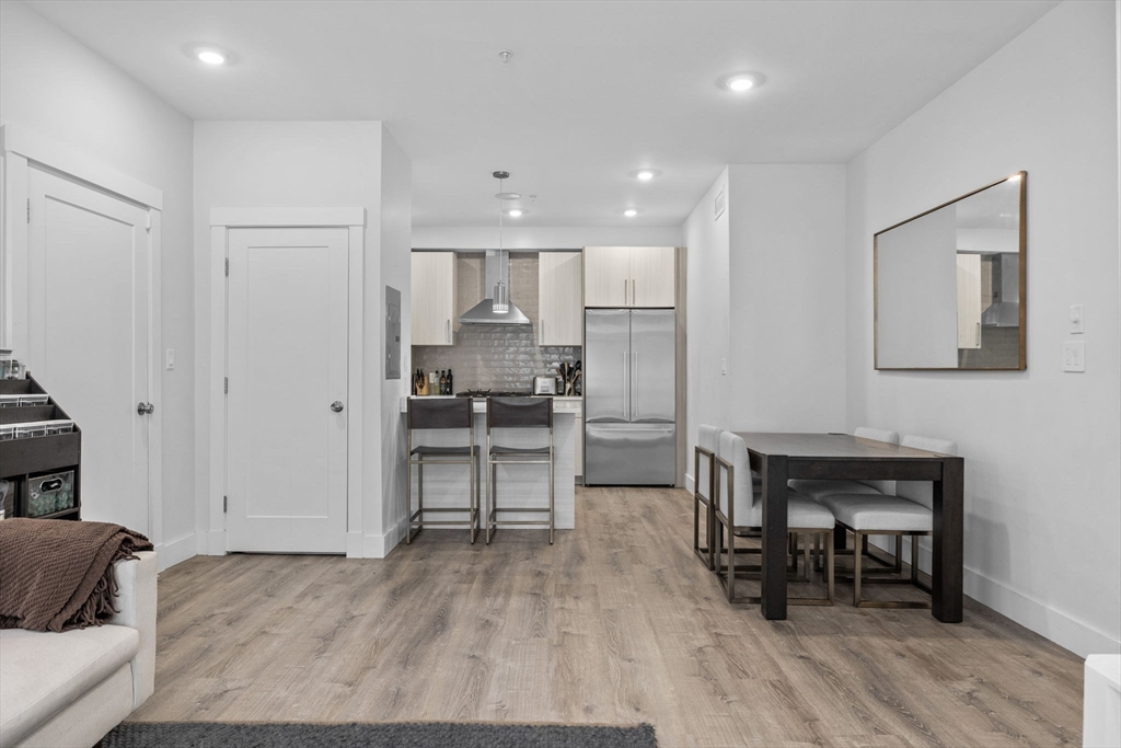 176 Humboldt Avenue, Unit 2 Boston, MA 02121 - Photo 5 of 23 a living room with furniture and a dining table with wooden floor