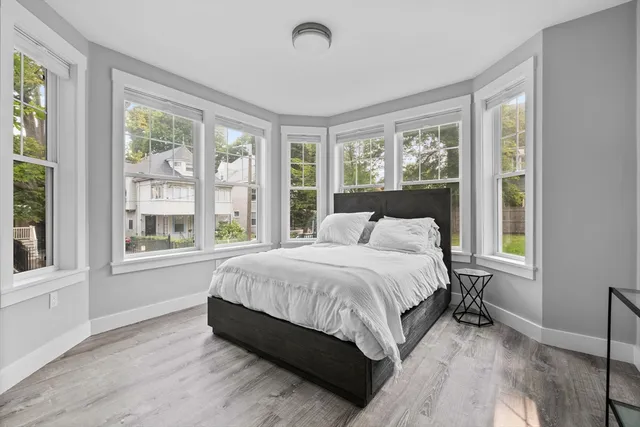 a large bed sitting in a bedroom next to a window