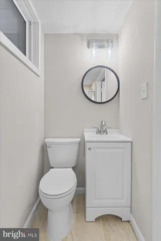 a bathroom with a toilet a sink and mirror