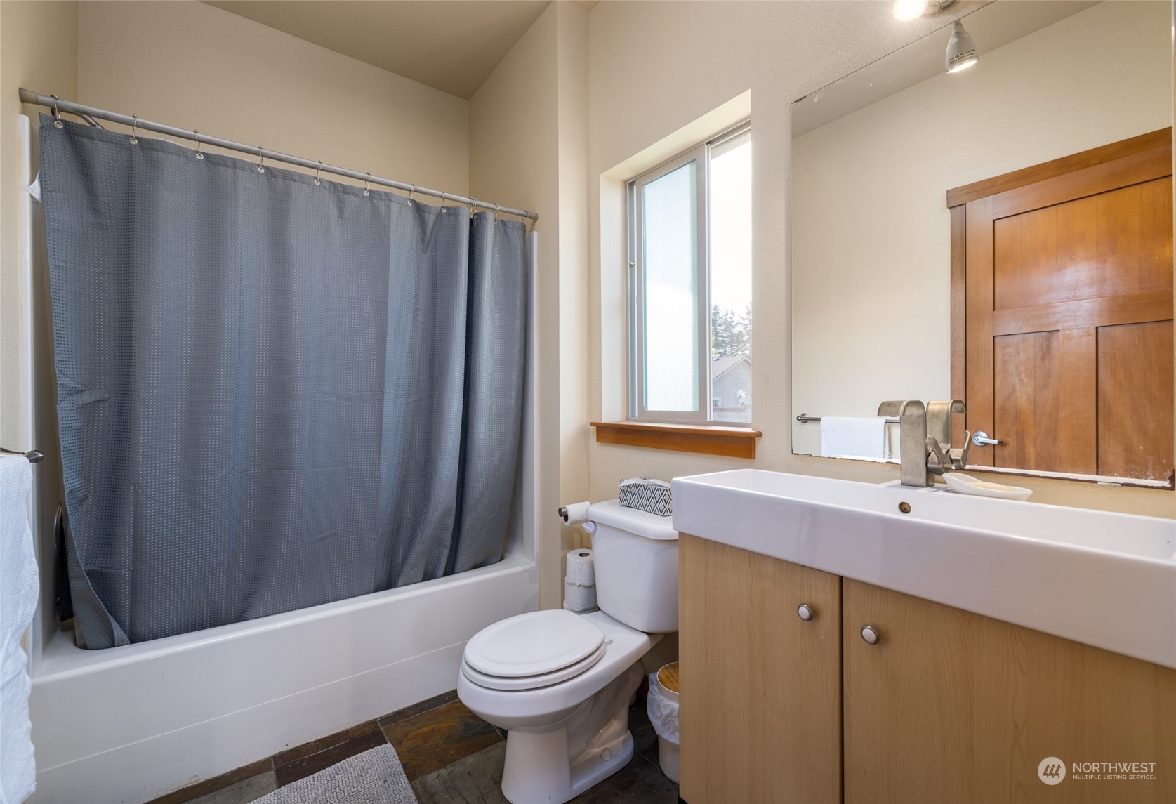 908 Mission Road Everson, WA 98247 - Photo 29 of 40 a bathroom with a sink a toilet a mirror and shower curtain