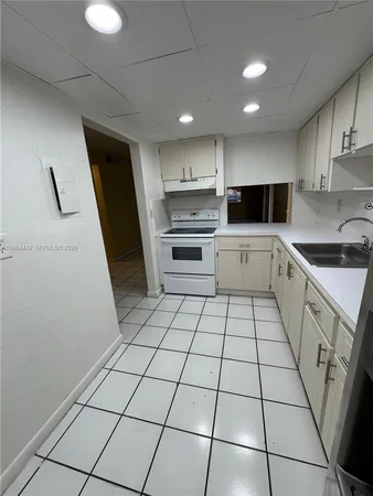 a kitchen with a sink a stove and cabinets
