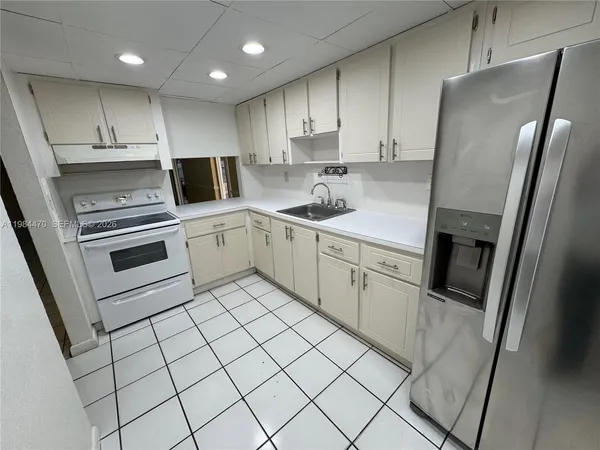 a kitchen with stainless steel appliances a refrigerator sink and microwave