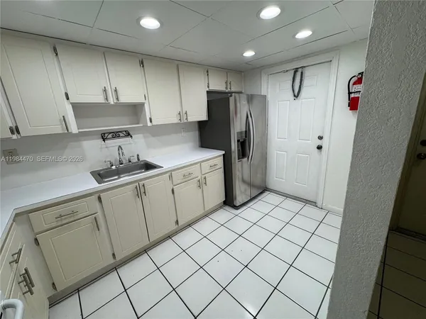 a kitchen with stainless steel appliances a refrigerator sink and cabinets
