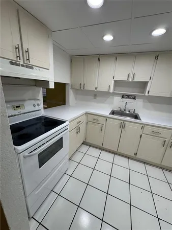 a kitchen with a sink a stove and cabinets