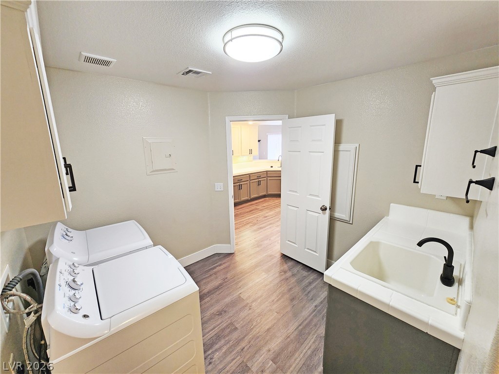 4591 Stoneham Street Pahrump, NV 89061 - Photo 20 of 42 Functional laundry room featuring durable vinyl flooring and a convenient utility sink.