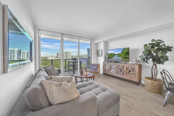 a living room with furniture and floor to ceiling window