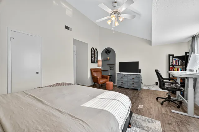 a bedroom with a large bed and a chandelier