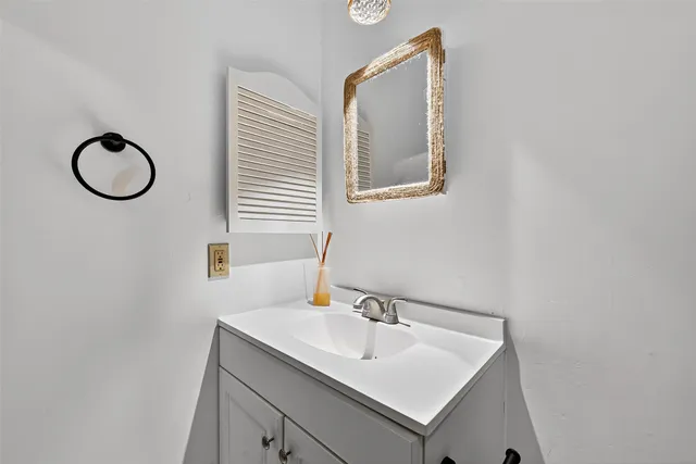 a bathroom with a sink vanity and a mirror