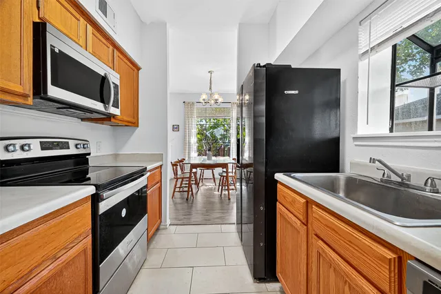 a kitchen with stainless steel appliances granite countertop a refrigerator a stove top oven a sink and dishwasher