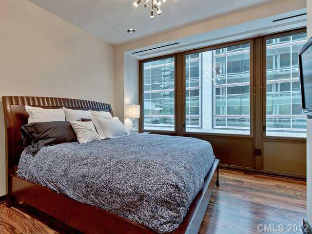 139 South Tryon Street, Unit 3B Charlotte, NC 28202 - Photo 15 of 16 a bedroom with a large bed and a large window