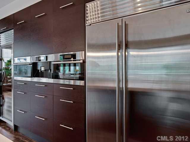 139 South Tryon Street, Unit 3B Charlotte, NC 28202 - Photo 3 of 16 a kitchen with stainless steel appliances kitchen island a refrigerator and sink