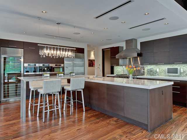139 South Tryon Street, Unit 3B Charlotte, NC 28202 - Photo 4 of 16 a kitchen with stainless steel appliances granite countertop a table chairs and a wooden floor