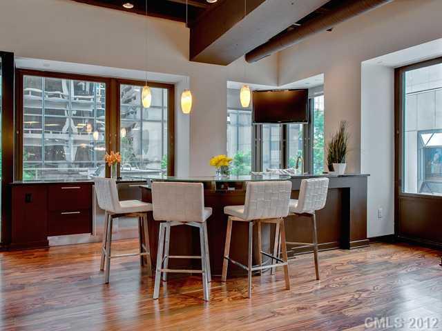 139 South Tryon Street, Unit 3B Charlotte, NC 28202 - Photo 5 of 16 a view of a dining room with furniture and wooden floor