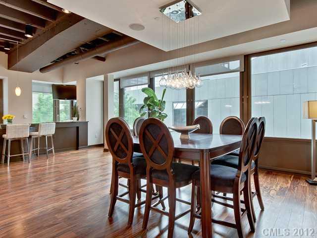 139 South Tryon Street, Unit 3B Charlotte, NC 28202 - Photo 7 of 16 a view of a dining room with furniture and wooden floor