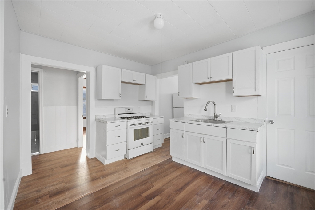a kitchen with granite countertop white cabinets and white appliances
