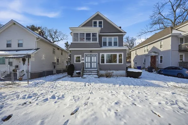 a view of a house with a yard covered in snow