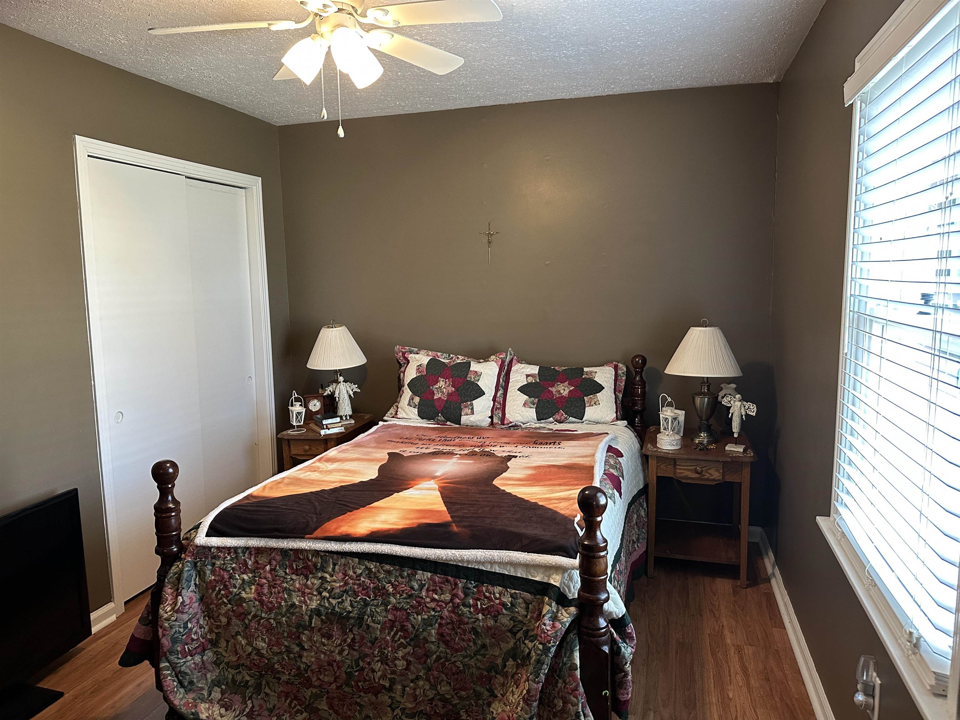 92 Puron Road Adamsville, TN 38310 - Photo 16 of 23 a bedroom with a bed and a chandelier