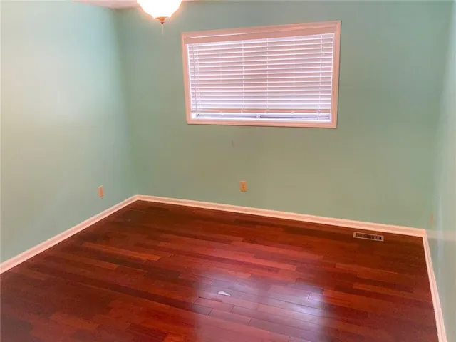 a view of a room with wooden floor and a window