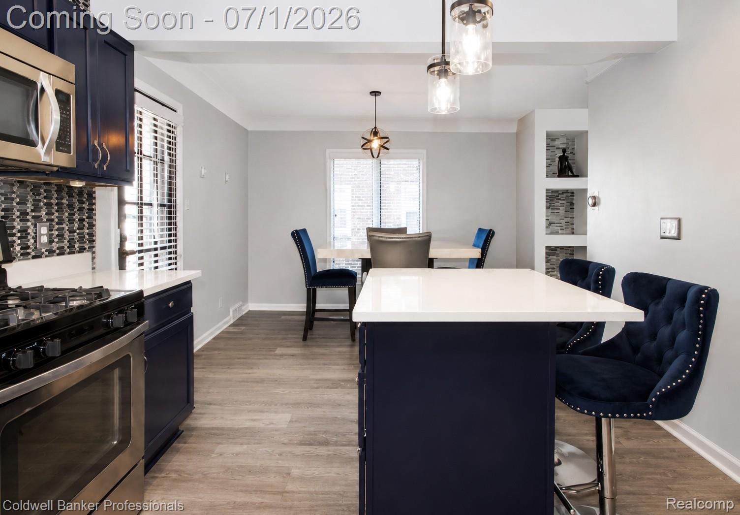 1168 Vernier Road Grosse Pointe, MI 48236 - Photo 13 of 32 Kitchen featuring navy cabinetry, stainless steel appliances, a tile backsplash, and wood-finish flooring