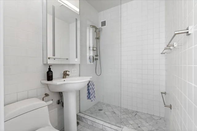 a bathroom with a sink toilet and shower