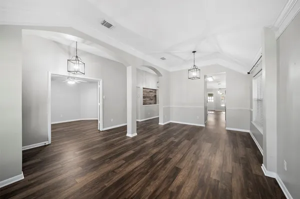 a view of a livingroom with a fireplace a ceiling fan and wooden floor