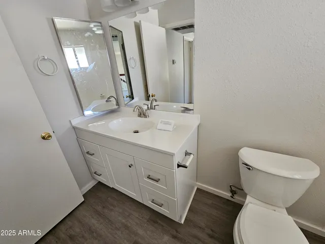 a bathroom with a toilet sink and mirror