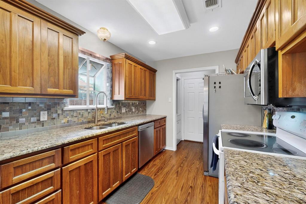 6617 Whitley Road Watauga, TX 76148 - Photo 12 of 36 a kitchen with stainless steel appliances granite countertop a sink stove and refrigerator