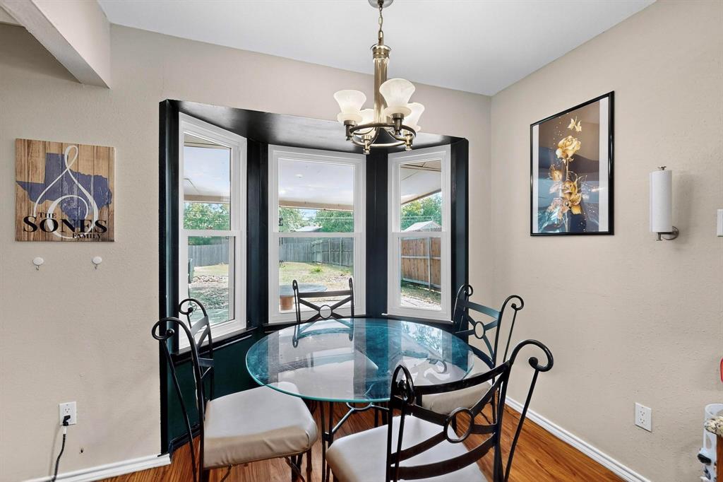 6617 Whitley Road Watauga, TX 76148 - Photo 16 of 36 a dining room with furniture a potted plant and a chandelier