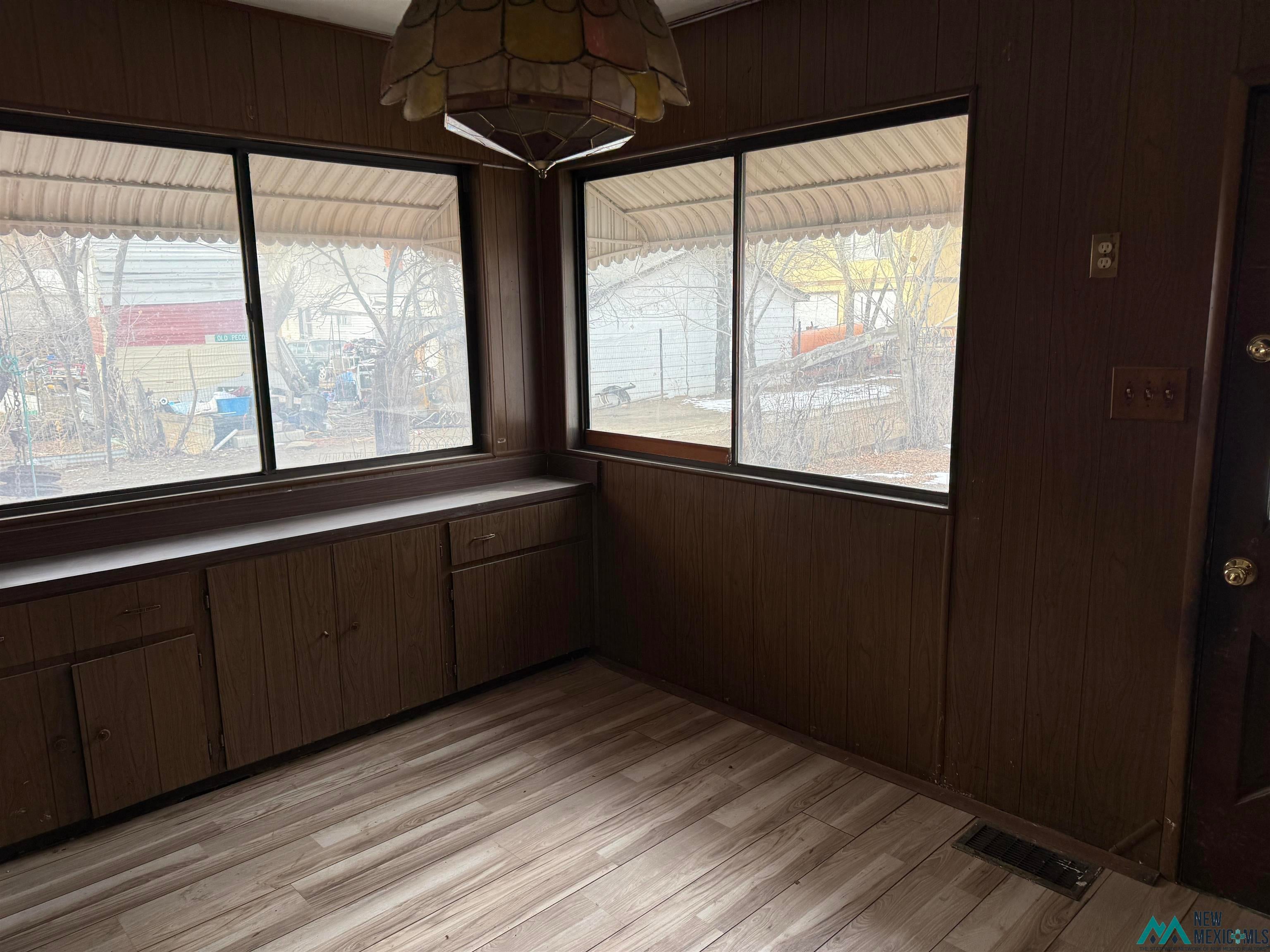 524 South 1st Street Raton, NM 87740 - Photo 7 of 21 Unfurnished dining area featuring wooden walls and light wood-type flooring