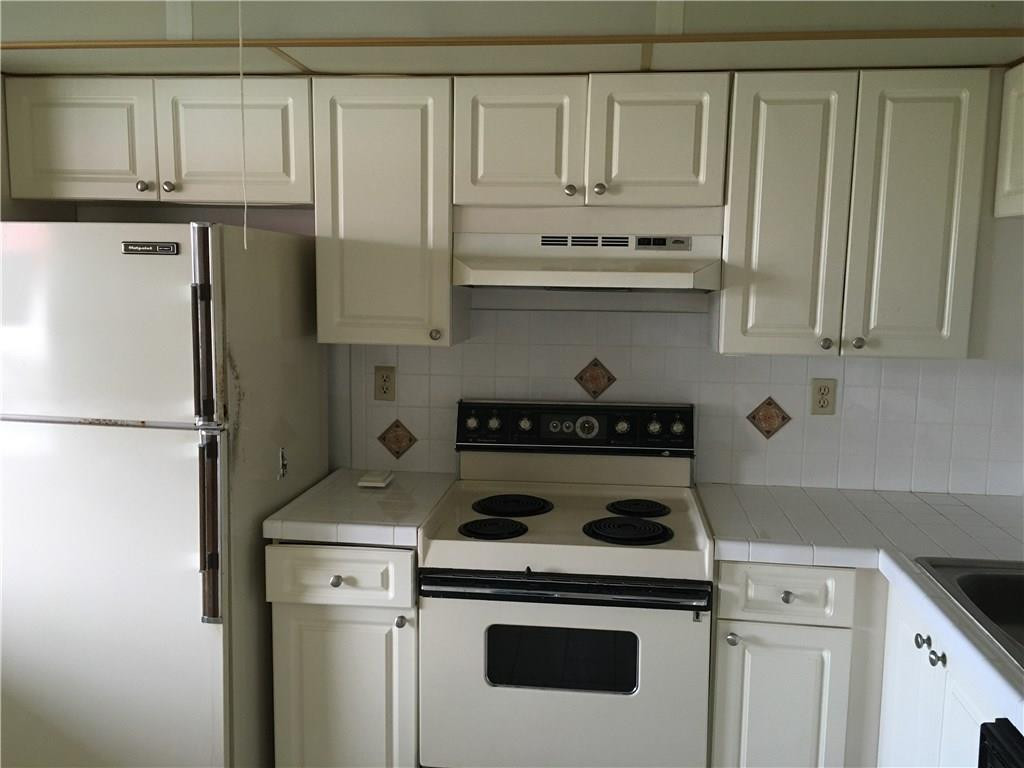 3601 Inverrary Drive, Unit 402 Lauderhill, FL 33319 - Photo 4 of 14 a kitchen with white cabinets and white stainless steel appliances