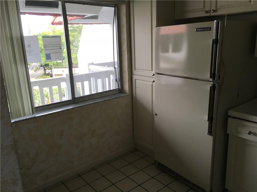 3601 Inverrary Drive, Unit 402 Lauderhill, FL 33319 - Photo 5 of 14 a view of a refrigerator in kitchen and wooden floor