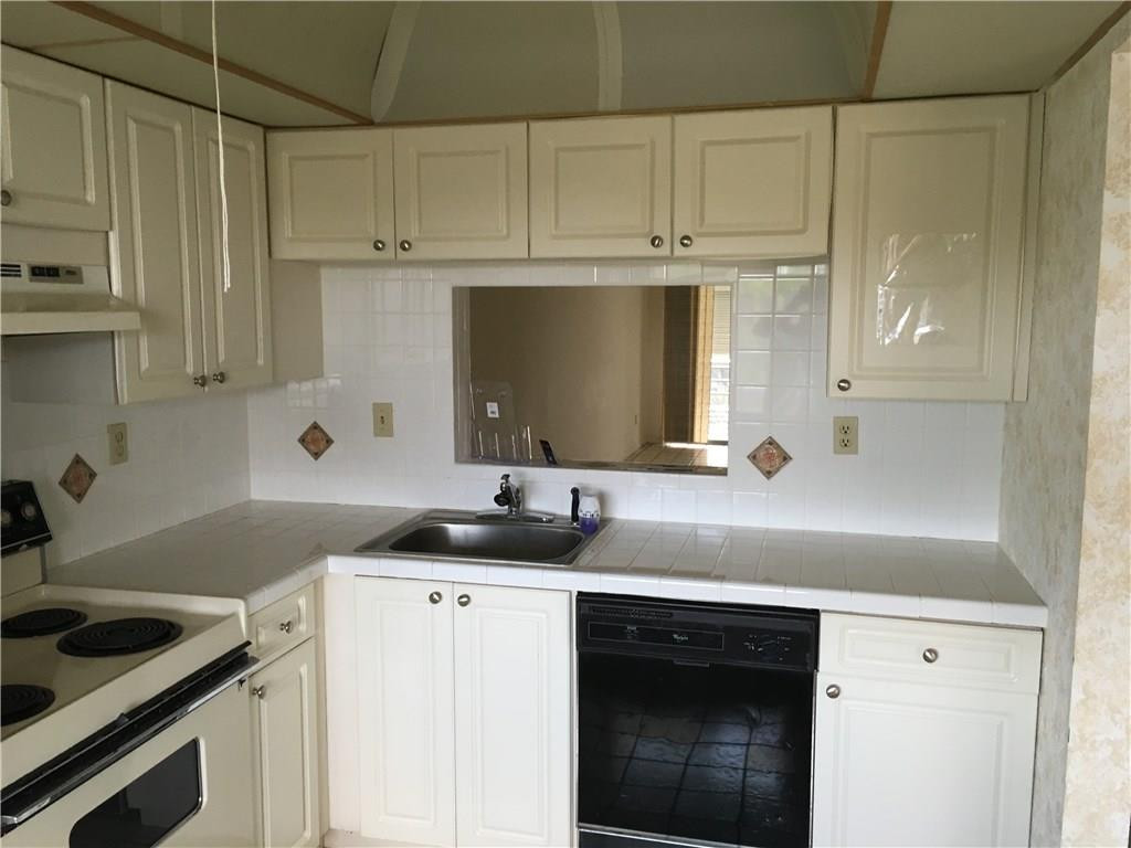 3601 Inverrary Drive, Unit 402 Lauderhill, FL 33319 - Photo 6 of 14 a kitchen with stainless steel appliances granite countertop a sink stove and cabinets