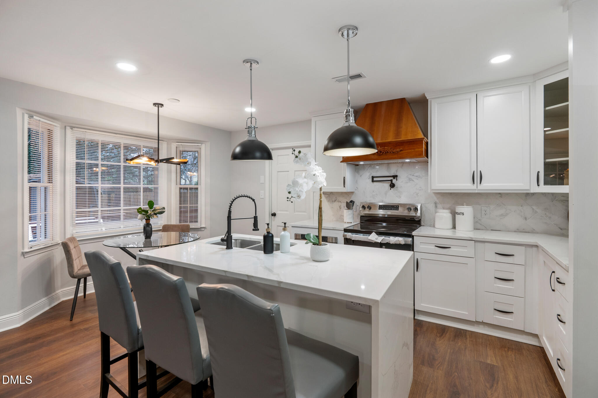 6604 Winding Trail Raleigh, NC 27612 - Photo 18 of 49 a kitchen with stainless steel appliances kitchen island granite countertop a sink a stove a dining table and chairs
