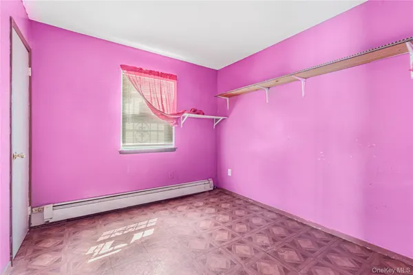 a view of a room with pink walls and a window