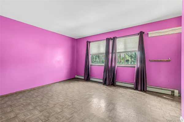 a view of empty room with floor to ceiling window and carpet