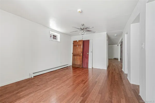 a view of a room with wooden floor and a ceiling fan