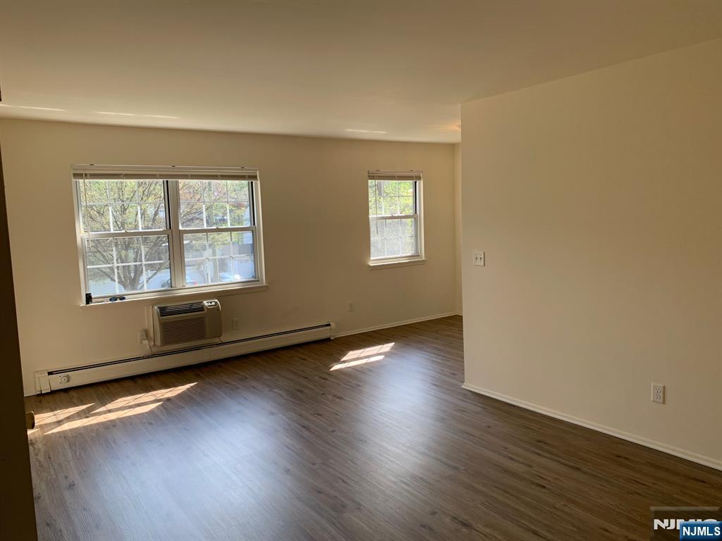 153 Park Avenue, Unit 153C Park Ridge, NJ 07656 - Photo 11 of 21 an empty room with wooden floor and windows