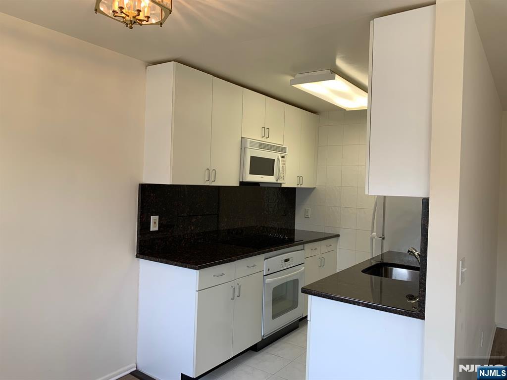 153 Park Avenue, Unit 153C Park Ridge, NJ 07656 - Photo 12 of 21 a kitchen with a sink and a stove top oven