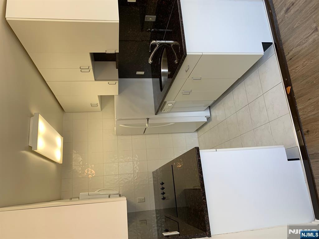 153 Park Avenue, Unit 153C Park Ridge, NJ 07656 - Photo 14 of 21 a kitchen with a sink a stove and cabinets