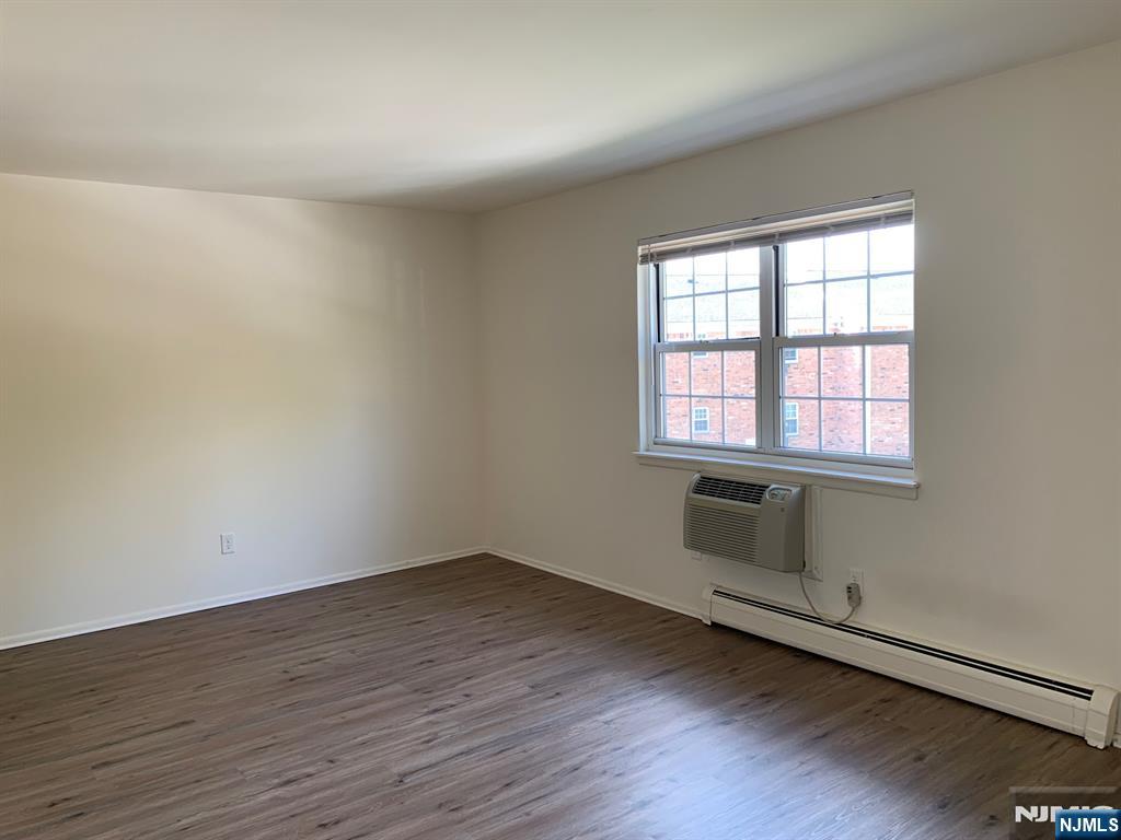 153 Park Avenue, Unit 153C Park Ridge, NJ 07656 - Photo 18 of 21 an empty room with wooden floor and windows