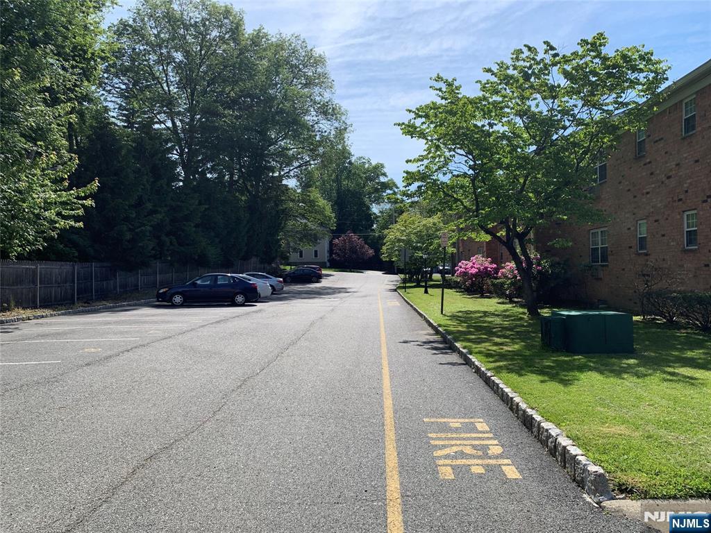 153 Park Avenue, Unit 153C Park Ridge, NJ 07656 - Photo 7 of 21 a view of patio with a table and chairs a barbeque with potted plants and big trees