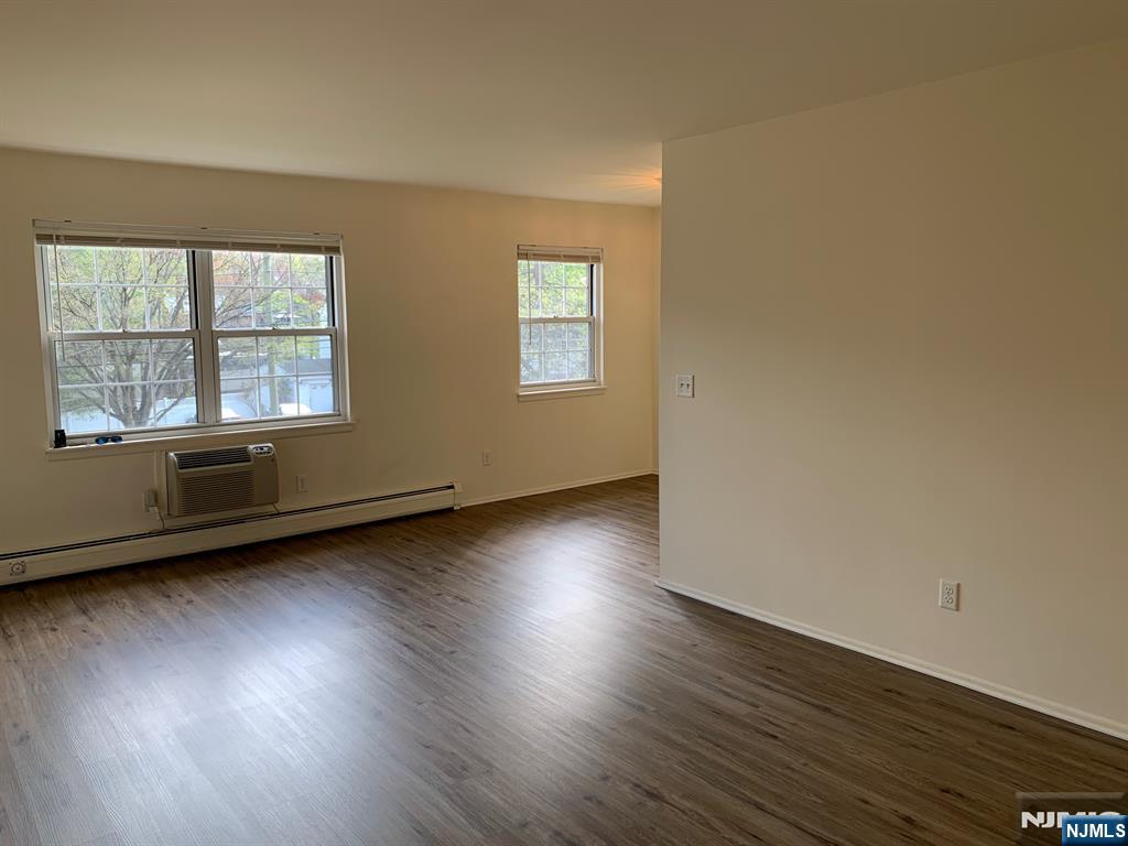 153 Park Avenue, Unit 153C Park Ridge, NJ 07656 - Photo 10 of 21 an empty room with wooden floor and windows
